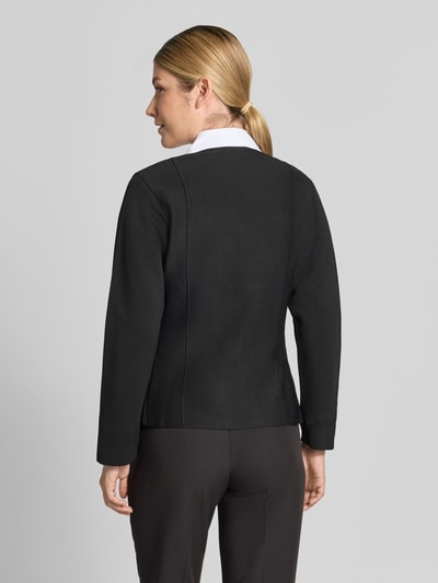 Frauenmodel trägt Cardigan mit Zierknöpfen Modell 'APOLLO' von MANGO in Schwarz, strukturierte Oberfläche, gerade Form, Ganzkörperansicht Rückansicht.