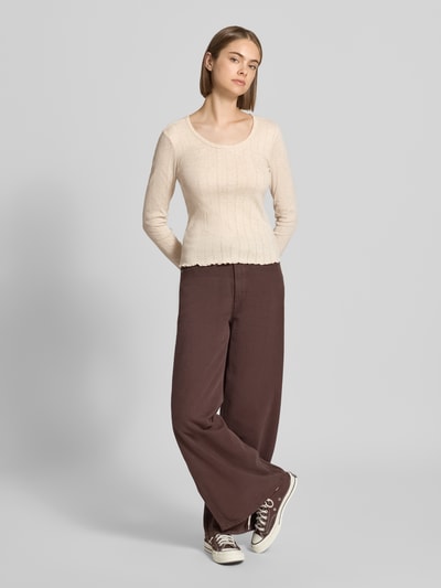 Frauenmodel trägt Slim Fit Langarmshirt mit Baumwoll-Anteil Modell 'TENNA' von ONLY, beige Farbe, zarte Rippenstruktur, Ganzkörperansicht von vorne, Damen Langarmshirt von ONLY.