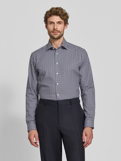 Mannelijk model draagt Regular Fit Businesshemd aus elastischem Baumwoll-Mix van Christian Berg Men met Kentkraag en knoopsluiting in zwart-wit ruitpatroon, regular fit, ruglengte 78 cm, schouderbreedte 48 cm, mouwlengte 66 cm, mix van katoen en elastaan, zakelijk overhemd, Heren, voorkant bovenlichaam.
