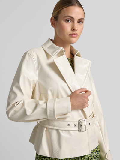Frauenmodel trägt Jacke mit Gürtel und Ärmelriegeln von Marc Cain in Creme, Hakenverschluss, Regular-Fit, strukturierte Oberfläche, Nahaufnahme Oberkörper, Rückenlänge bei Größe 36: 58 cm, Schulterbreite: 40 cm, Brustweite: 48 cm, Ärmellänge: 61 cm.