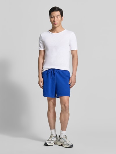 Männermodel trägt Slim Fit T-Shirt mit Rundhalsausschnitt Modell 'Sonoma' von American Vintage in Weiß, reine Baumwolle, Ganzkörperansicht von vorne.