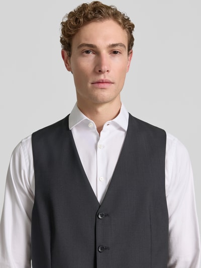 Männermodel trägt Weste mit V-Ausschnitt und Paspeltaschen Modell 'Tobias' von Carl Gross, Reine Schurwolle, Slim-Fit, Knopfleiste, Nahaufnahme Oberkörper.