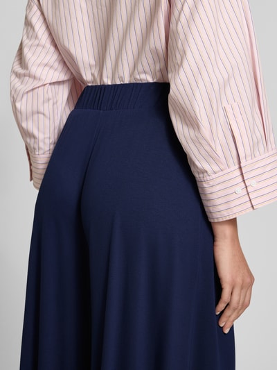Frauenmodel trägt Loose Fit Culotte aus Viskose-Mix von Armedangels in Dunkelblau, elastischer Bund, Jersey-Struktur, Nahaufnahme Rückansicht.