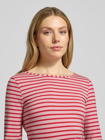 Kobiece model nosi bluzkę z długim rękawem z bawełny, krój slim fit, model 'SUMIKO' od Oui, okrągły prążkowany dekolt, rozmiar 36, długość tyłu 63 cm, pasy czerwone i różowe, faktura gładka, nahaufnahme oberkörper.