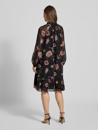 Vrouwenmodel draagt Knielanges Kleid met Schluppe van Oui, zwart met all-over bloemenprint, A-lijn, laagjeslook, knielengte, ruglengte maat 36: 99 cm, borstwijdte maat 36: 52 cm, mouwlengte maat 36: 54 cm, geheelfiguur achteraanzicht.