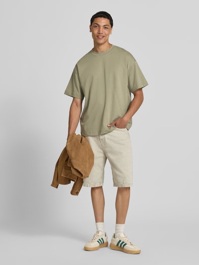 Männermodel trägt Herren T-Shirt mit Rundhalsausschnitt Modell 'BARRON' von Jack & Jones, Baumwoll-Mix mit Stretch-Anteil, Relaxed-Fit, Rückenlänge 73 cm, sandfarbene Töne, glatte Textur, Ganzkörperansicht von vorne.