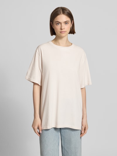 Frauenmodel trägt Oversized T-Shirt mit Label-Stitching von OH APRIL aus Reine Baumwolle, Rundhalsausschnitt, Rückenlänge 70 cm, Ganzkörperansicht von vorne.