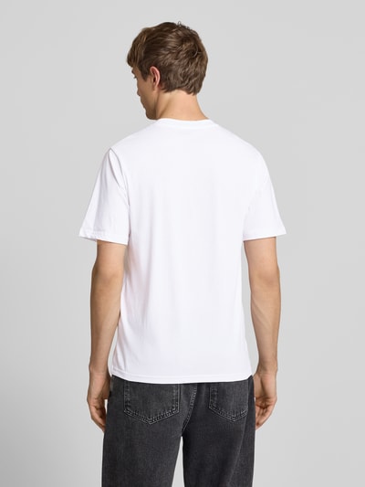 Männermodel trägt Herren T-Shirt im 3er-Pack mit Statement-Print Modell 'DUST' von Jack & Jones aus Reine Baumwolle, Ganzkörperansicht Rückansicht.