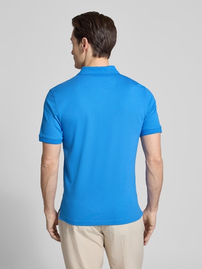 Männermodel trägt Slim Fit Poloshirt aus Baumwoll-Mix Modell 'Pete' von BRAX in Blau, Polokragen, Rückenlänge 71 cm, Ganzkörperansicht Rückansicht.