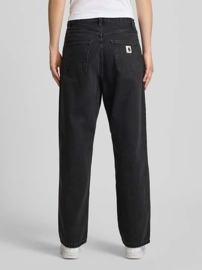 Frauenmodel trägt Relaxed Fit Jeans mit Eingrifftaschen Modell 'Brandon' von Carhartt Work In Progress aus Reine Baumwolle in Schwarz, Ganzkörperansicht Rückansicht. Bundweite bei Größe 27: 40 cm, Innenbeinlänge bei Größe 27: 72 cm.
