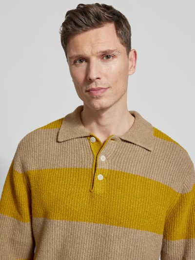 Männermodel trägt Strickpullover mit Polo-Kragen Modell 'Kimse' von Wood Wood aus Baumwoll-Mix in Beige und Gelb, Nahaufnahme Oberkörper.