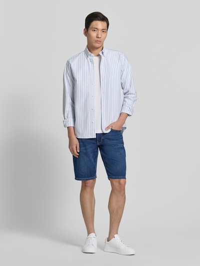 Männermodel trägt Regular Fit Jeansshorts aus Baumwoll-Mix von s.Oliver RED LABEL in Denim-Optik mit Label-Patch, Nieten, 5-Pocket-Design, Ganzkörperansicht von vorne.