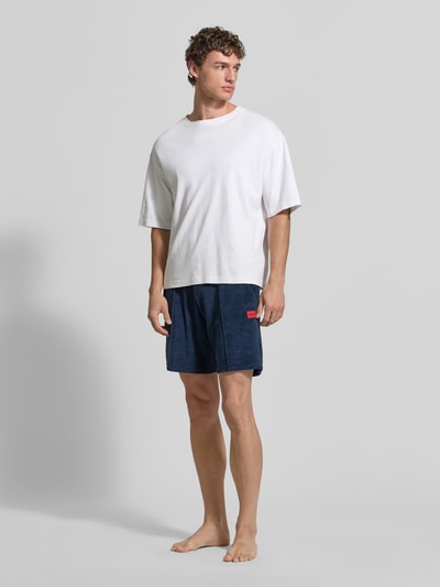 Männermodel trägt Regular Fit Sweatshorts aus Baumwoll-Mix Modell 'TERRANCE' von HUGO, Optik: Unifarben, Ganzkörperansicht von vorne.