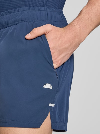 Männermodel trägt Shorts mit elastischem Bund Modell 'ERUDITO' von Ellesse in Blau, Material-Mix mit Stretch-Anteil, Nahaufnahme Oberschenkel.