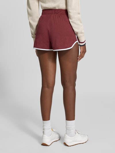 Frauenmodel trägt Regular Fit Shorts mit elastischem Bund Modell 'Marty' von VARLEY, Material-Mix, verlängerte Rückseite, Ganzkörperansicht Rückansicht.