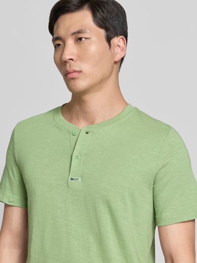Männermodel trägt Regular Fit T-Shirt aus reiner Baumwolle von s.Oliver RED LABEL in Optik: Unifarben, Henley-Kragen, Nahaufnahme Oberkörper.