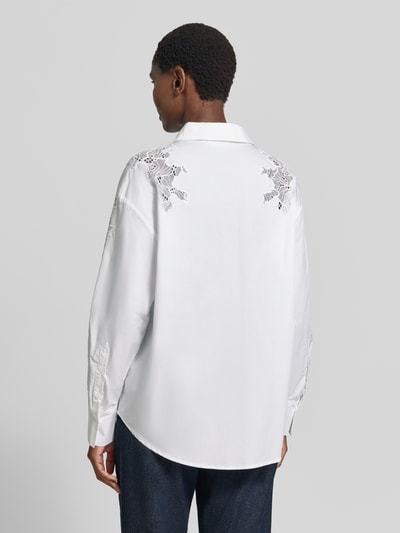 Vrouwenmodel draagt Bluse mit Spitze und Hemdblusenkragen Modell 'SHIRLEY' van Cph Muse, puur katoen, regular fit, witte kleur, knoopsluiting, sportmanchet, afgeronde zoom, kantdetails op schouders, ruglengte maat S 73 cm, mouwlengte maat S 45 cm, geheel achteraanzicht.