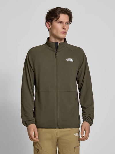 Männermodel trägt Jacke mit Raglanärmeln und Logo-Print Modell 'PACKABLE KECHA' von The North Face in Oliv, Reißverschluss, Material-Mix, Gerader Schnitt, Ganzkörperansicht von vorne.
