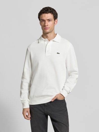 Männermodel trägt Regular Fit Sweatshirt aus reiner Baumwolle von Lacoste in Weiß, strukturierte Oberfläche, Ganzkörperansicht von vorne. Herren Sweatshirt von Lacoste