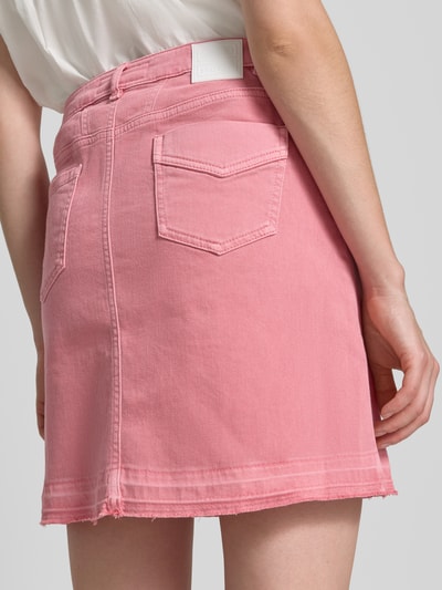 Vrouwenmodel draagt Straight Fit Minirok in denimlook van Marc Cain, katoenmix, steek- en achterzakken, knoop- en ritssluiting, totale lengte maat 36: 44 cm, bandwijdte maat 36: 37 cm, roze kleur, textuur van denim, detailopname achterkant.