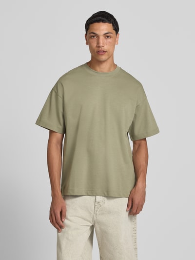 Männermodel trägt Herren T-Shirt mit Rundhalsausschnitt Modell 'BARRON' von Jack & Jones aus Baumwoll-Mix mit Stretch-Anteil, Relaxed-Fit, dezentes Hellgrün, glatte Textur, Rückenlänge bei Größe M 73 cm, Ganzkörperansicht von vorne.
