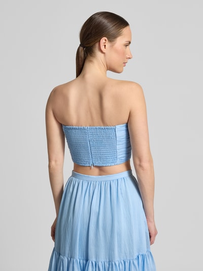 Modelka nosi top bandażowy z marszczeniami 'Bandeau Top mit Raffungen' od Jake*s Cocktail, mieszanka lyocellu i lnu, dopasowany krój, jasnoniebieski, długość tyłu w rozmiarze 36: 23 cm, całkowity widok z tyłu.