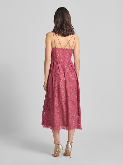 Frauenmodel trägt Knielanges Cocktailkleid mit Spitze und Spaghettiträgern von Jake*s Cocktail, Baumwoll-Mix, taillierter Schnitt, Knielänge, doppelte Spaghettiträger, V-Ausschnitt, Rückseite mit Haken- und Reißverschluss, Unterkleid, Spitzenstruktur in Rosé, Ganzkörperansicht Rückansicht.