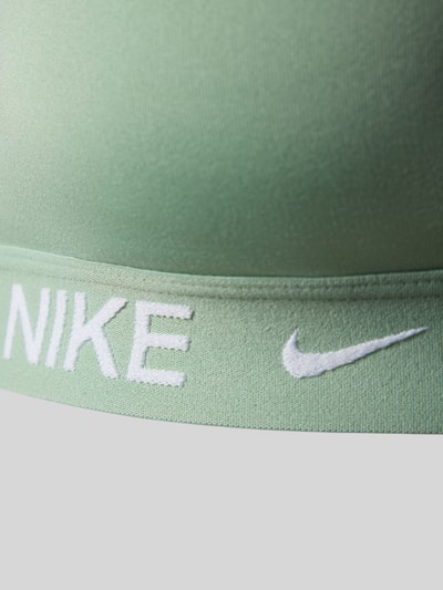 Frauenmodel trägt Slim Fit Sport-BH mit Logo-Print Modell 'Indy' von NIKE TRAINING aus Elastischer-Material-Mix, Nahaufnahme Oberkörper.