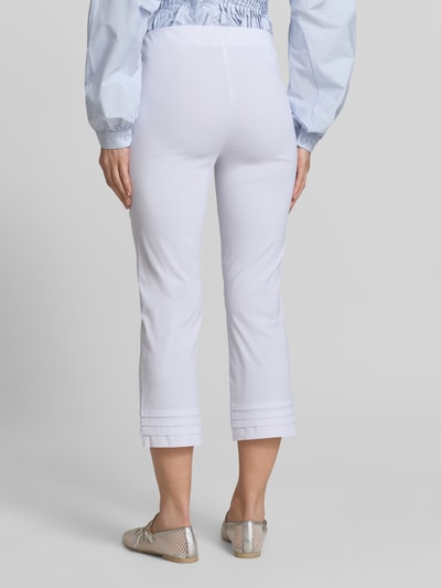 Männermodel trägt Caprihose aus Viskose-Mix Modell 'Ina' von STEHMANN, krój slim fit, drapowania, kolor biały, Ganzkörperansicht Rückansicht. Szerokość w rozmiarze 36: 38 cm, długość wewnętrzna nogawki: 59 cm.
