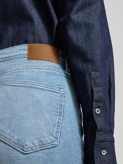 Vrouwenmodel draagt Bootcut Jeans aus Baumwoll-Mix van s.Oliver RED LABEL in lichtblau denim, label patch, detailopname rug.