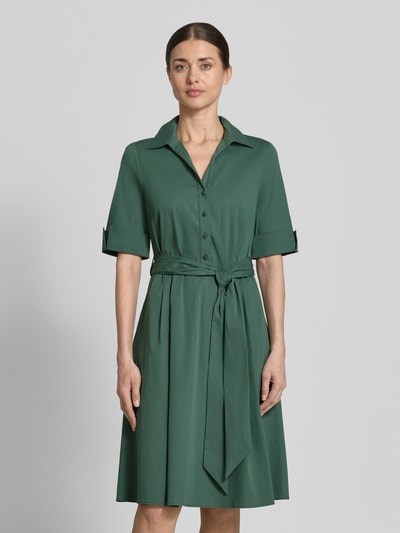 Frauenmodel trägt Knielanges Hemdblusenkleid mit Bindegürtel von ROBE LÉGÈRE in sattem Grün, Baumwoll-Mix mit Stretch-Anteil, Taillierter Schnitt, Hemdblusenkragen, kurze Knopfleiste, Bindegürtel, Ärmel mit Aufschlag, Rückenlänge bei Größe 36: 104 cm, Brustweite: 42 cm, Ärmellänge: 30 cm, glatte Struktur, Ganzkörperansicht von vorne.