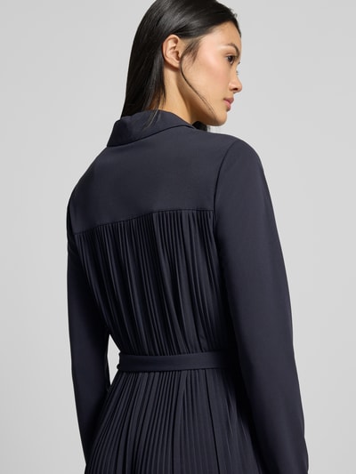 Vrouwenmodel draagt donkerblauwe midi-jurk met plooien, opstaande kraag, knoopsluiting en tailleband, Model 'FRAGOLA' van MM by Max Mara, getailleerde pasvorm, met lange mouwen, midilengte, ruglengte maat S 118 cm, borstwijdte maat S 48 cm, mouwlengte maat S 60 cm, geheel van achteren