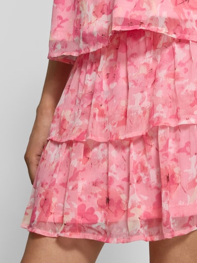 Vrouwenmodel draagt Mini-Rock aus Chiffon Modell 'SMILLA' van Vero Moda, roze allover-motief, uitlopend, mini, volants, gesmokte taille, close-up heupen.