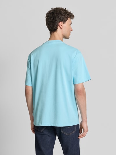 Männermodel trägt Oversized T-Shirt mit Rundhalsausschnitt von Lindbergh in Hellblau, reine Baumwolle, lockere Passform, Ganzkörperansicht Rückansicht.