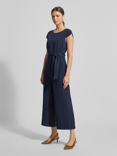Kobiece modelka nosi Kombinezon mit Bindegürtel von Christian Berg Woman Selection, mieszanka materiałów z dodatkiem streczu, krój regular fit, okrągły dekolt, całkowita długość 130 cm, długość tyłu 39 cm, szerokość w rozmiarze 36: 37 cm, długość rękawów 7 cm, długość wewnętrzna nogawki 61 cm, kolor granatowy, widok całej sylwetki z przodu.