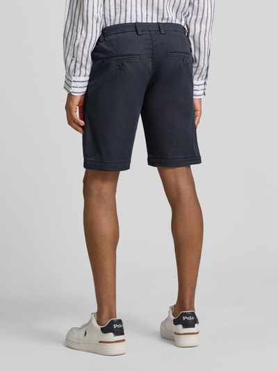 Männermodel trägt Bermudas mit Bindegürtel und französischen Eingrifftaschen von MAC, Dunkelblau, Baumwoll-Mix mit Stretch-Anteil, Ganzkörperansicht Rückansicht.