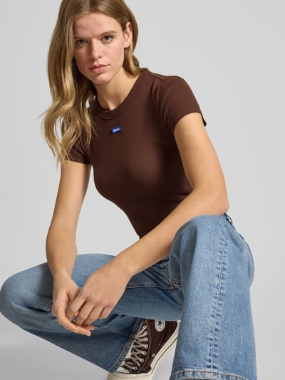 Vrouwenmodel draagt Slim Fit T-shirt uit katoenmix model 'BABY TEE_B' van Hugo Blue, effen look, ronde hals, korte mouw, ribstructuur, Nahaufnahme Oberkörper.