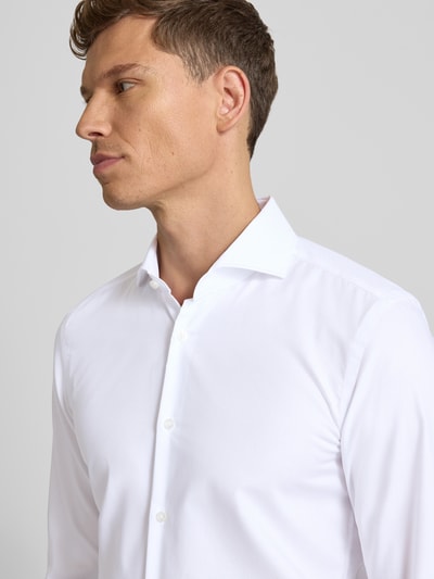 Männermodel trägt Slim Fit Businesshemd aus reiner Baumwolle Modell 'HANK' von BOSS, Optik: Unifarben, Nahaufnahme Oberkörper.