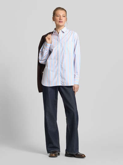Frauenmodel trägt Oversized Hemdbluse aus reiner Baumwolle von Lacoste mit Optik:Allover-Muster, Popeline, Label-Stitching, Ganzkörperansicht von vorne.