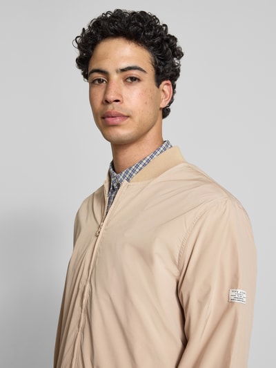 Männermodel trägt Regular Fit Bomberjacke mit College-Kragen Modell 'BELVEDERE' von Pepe Jeans, uni beige, label patch, Nahaufnahme Oberkörper.