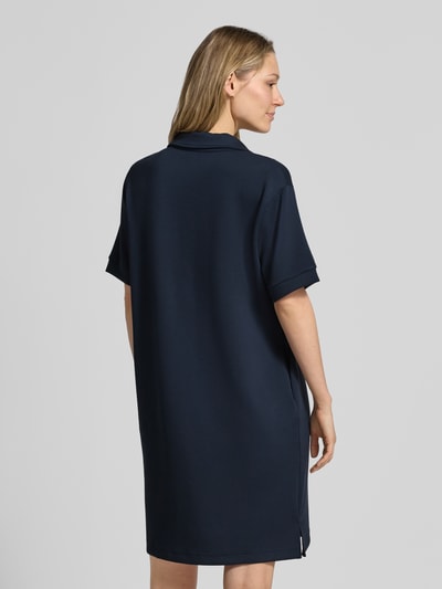 Frauenmodel trägt Regular Fit Polokleid mit Modal-Anteil von Marc O'Polo in Dunkelblau, unifarben, Mini-Länge, Rückansicht Ganzkörperansicht.