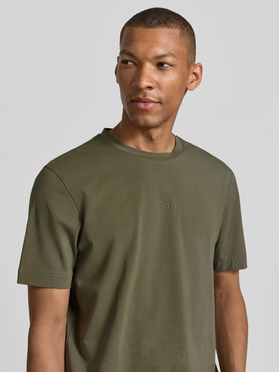 Męski model nosi Regular Fit T-Shirt aus Baumwoll-Mix Modell 'TCHUP' od BOSS Orange w kolorze oliwkowym, gładka tekstura, zbliżenie na górną część ciała, widok z przodu.