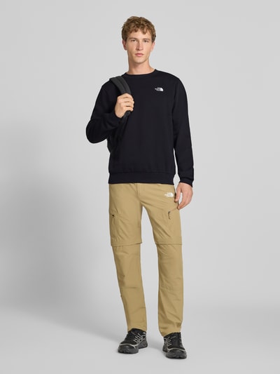 Männermodel trägt Regular Fit Sweatshirt Modell "EVOLUTION" von The North Face aus Baumwoll-Mix, elastische Abschlüsse, Ganzkörperansicht von vorne.