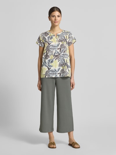 Frauenmodel trägt Relaxed Fit T-Shirt mit floralem Allover-Print von Soyaconcept aus reiner Baumwolle, Tunika-Ausschnitt, Ganzkörperansicht von vorne.