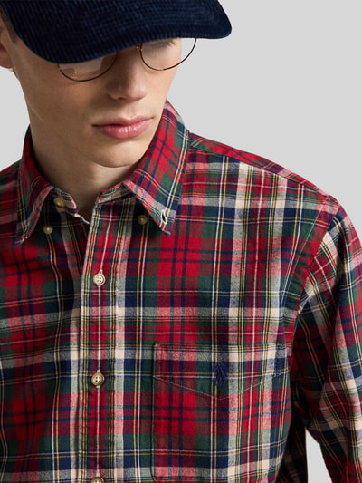 Männermodel trägt Custom Fit Freizeithemd aus reiner Baumwolle von Polo Ralph Lauren in Rot, Grün und Beige kariert, Nahaufnahme Oberkörper, Herren Freizeithemd von Polo Ralph Lauren.