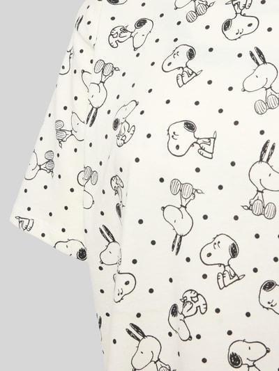 Frauenmodel trägt Pyjama-Oberteil mit Motiv-Print von Jake*s Casual aus reiner Baumwolle im Relaxed-Fit, weiße Grundfarbe, schwarze Punkte und Kontur-Motive, Rundhalsausschnitt, Nahaufnahme Oberkörper.