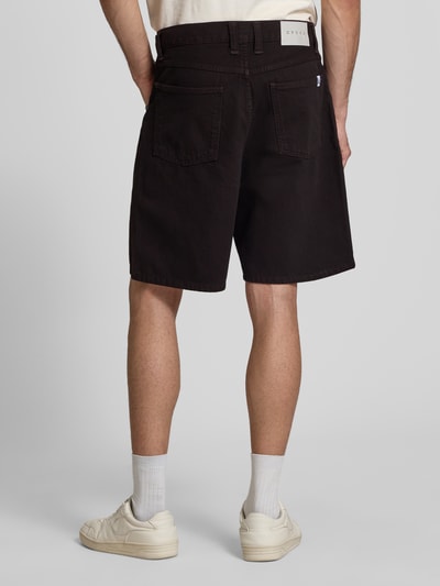 Männermodel trägt Straight Fit Shorts in Denim-Optik Modell 'Tyrell' von Edwin, reine Baumwolle, dunkler Ton, 5-Pocket-Design, Ganzkörperansicht Rückansicht.