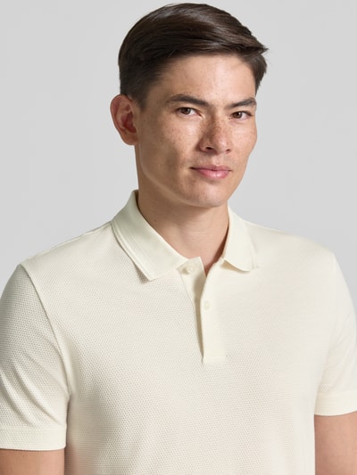Männermodel trägt Regular Fit Poloshirt aus katoenmix model 'PARLAY 240' van BOSS, effen, labelpatch, V-hals, korte mouw, Nahaufnahme Oberkörper.