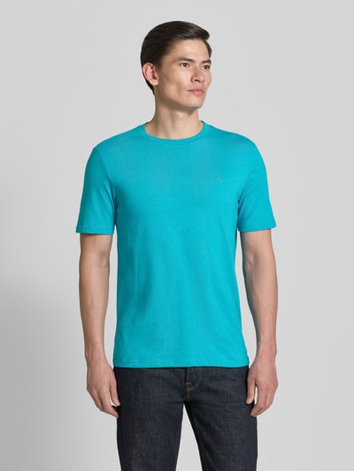 Männermodel trägt Regular Fit T-Shirt mit Logo-Stitching von Scotch & Soda in Türkis, aus reiner Baumwolle, Nahaufnahme Oberkörper.