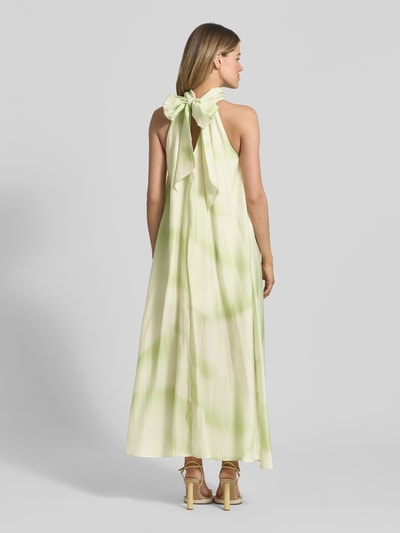 Frauenmodel trägt Neckholder-Maxikleid aus Lyocell-Mix Modell 'FIE' von Copenhagen Muse, A-Linie, grün-creme Farbverlauf, Ganzkörperansicht Rückansicht.